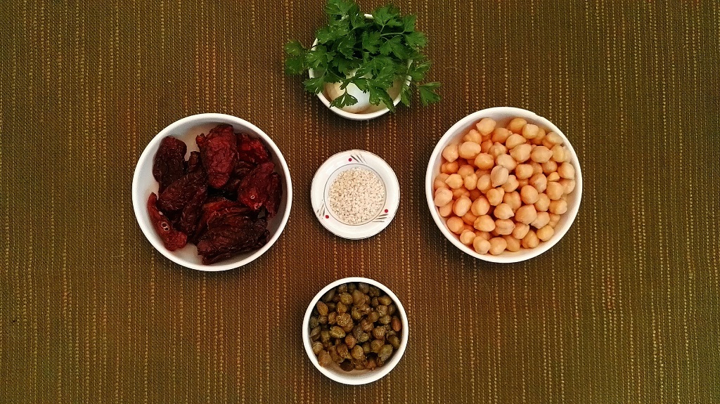 Ingredienti: ceci cotti, pomodori secchi, capperi, sesamo, aglio e prezzemolo