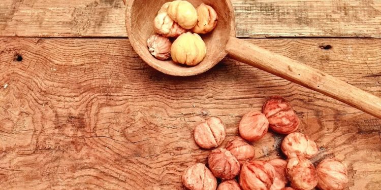 Castagne lessate, le pelate, su tavolaccio pronte in mestolo di legno e da pelare
