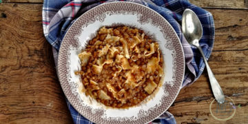 Minestra di lenticchie con lasagnette nel piatto con cucchiaio